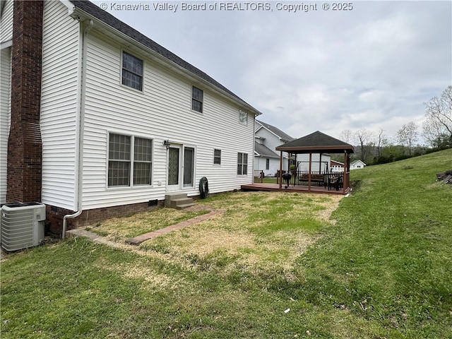 rear view of house featuring entry steps, a chimney, a gazebo, a yard, and central AC unit