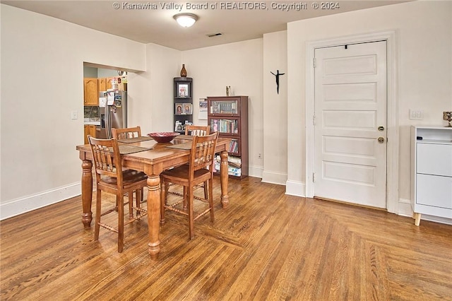 dining room with visible vents, parquet floors, and baseboards