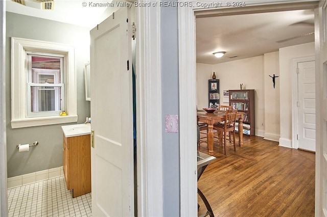 bathroom with visible vents, vanity, baseboards, and wood finished floors