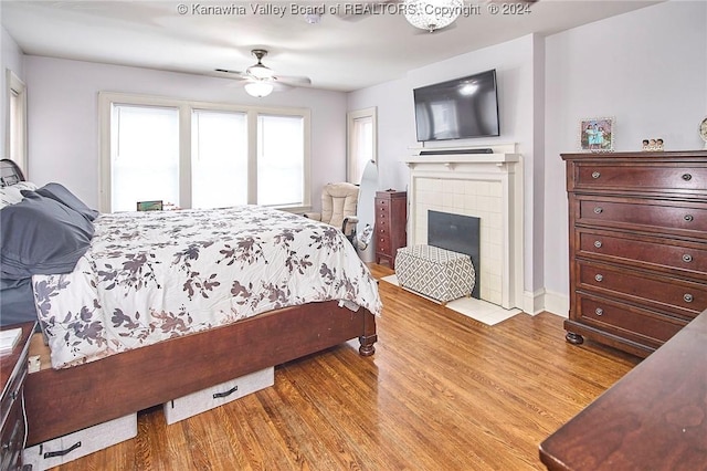 bedroom with a fireplace and light wood-style floors