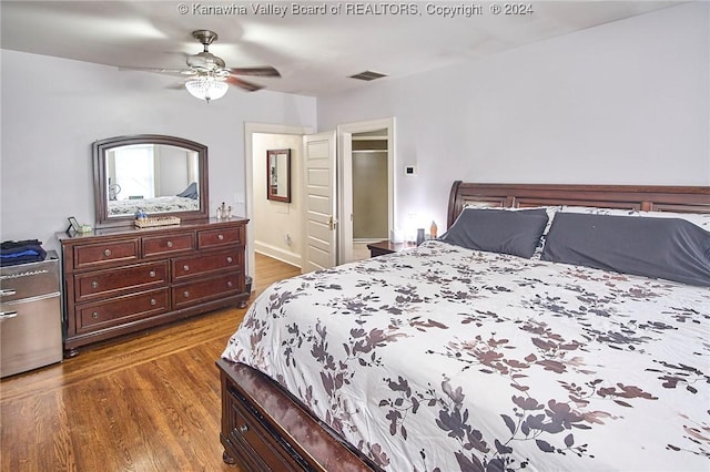 bedroom with ceiling fan, visible vents, and dark wood finished floors