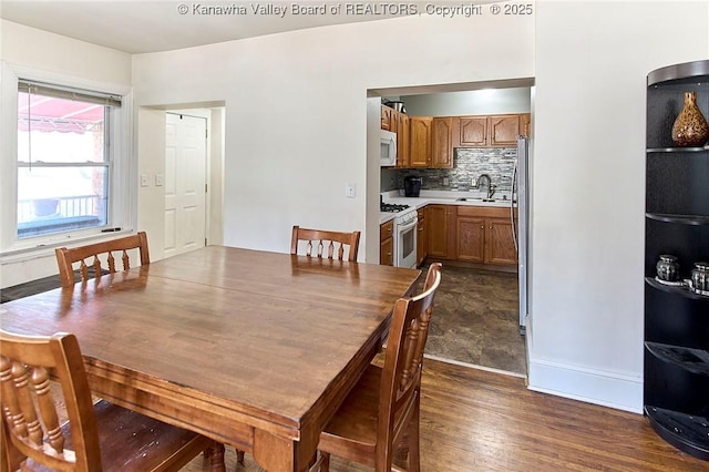 dining area with dark wood-type flooring and baseboards