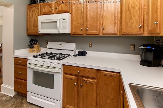 kitchen featuring brown cabinetry, white appliances, and light countertops