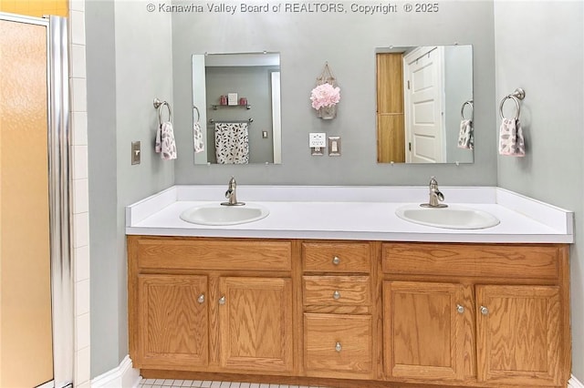 bathroom featuring a shower with door, double vanity, and a sink