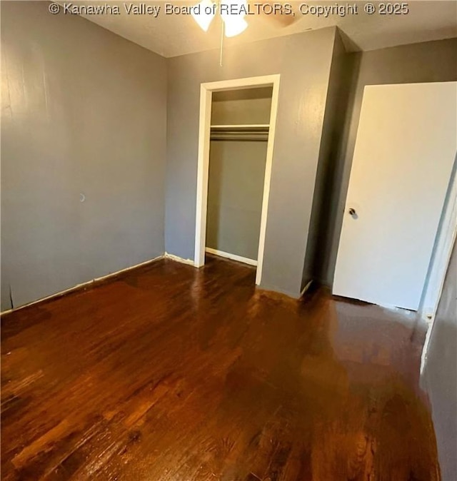 unfurnished bedroom featuring a closet and dark wood-type flooring