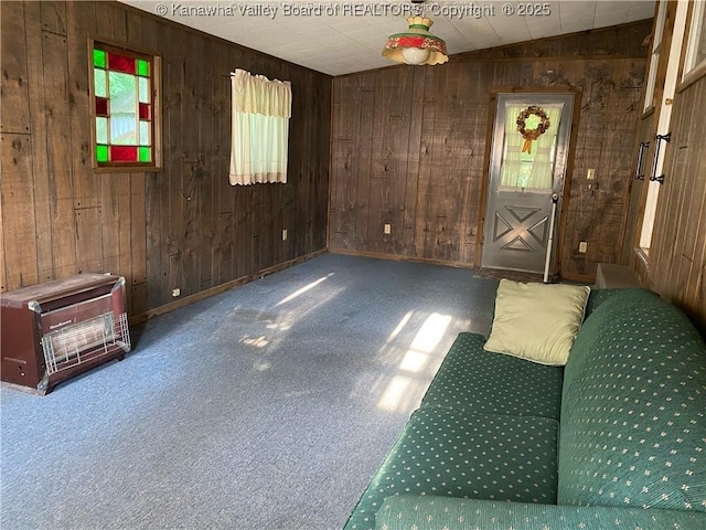 carpeted foyer entrance featuring wooden walls