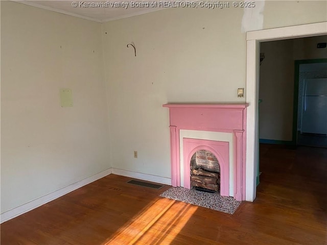 unfurnished living room with wood-type flooring and ornamental molding