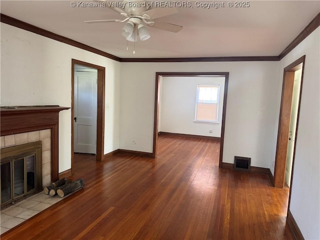 unfurnished living room with dark wood-style floors, visible vents, a fireplace, and crown molding