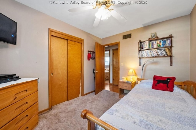 carpeted bedroom featuring ceiling fan and a closet