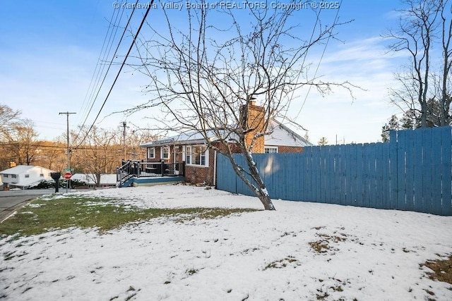 yard covered in snow with a wooden deck