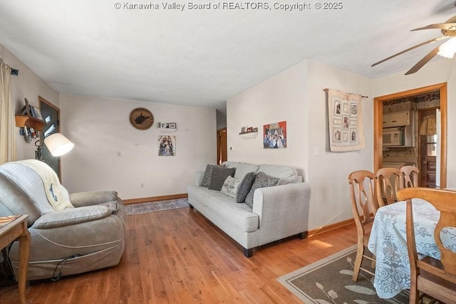 living room with ceiling fan and light hardwood / wood-style flooring