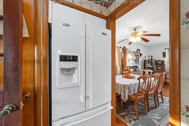 kitchen with hardwood / wood-style floors, ceiling fan, and white fridge with ice dispenser