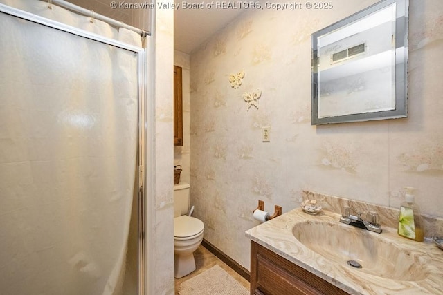 bathroom with vanity, toilet, and a shower with door