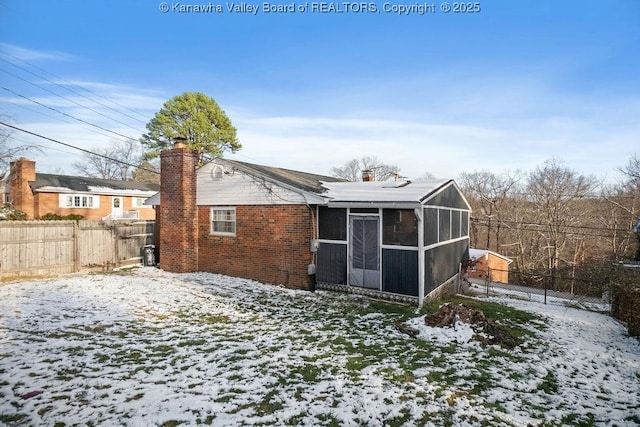 snow covered house with a sunroom