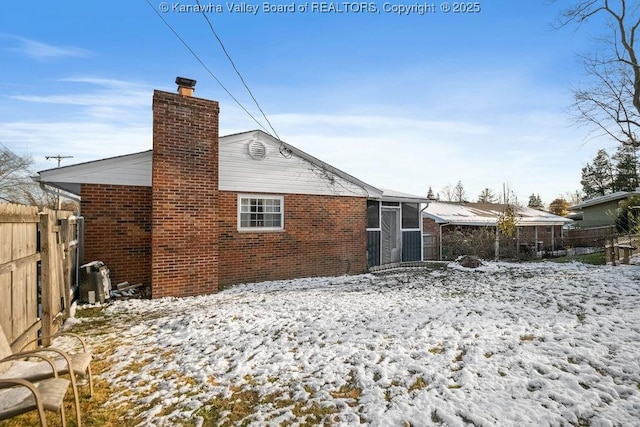 snow covered property with a sunroom