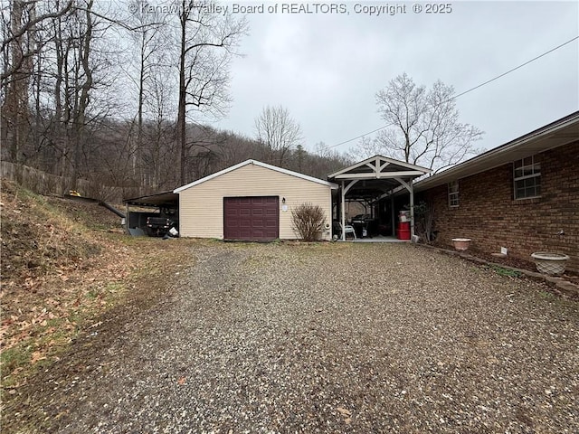 view of property exterior with a garage, a carport, and an outdoor structure