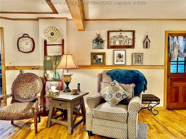 living area featuring beam ceiling and hardwood / wood-style flooring