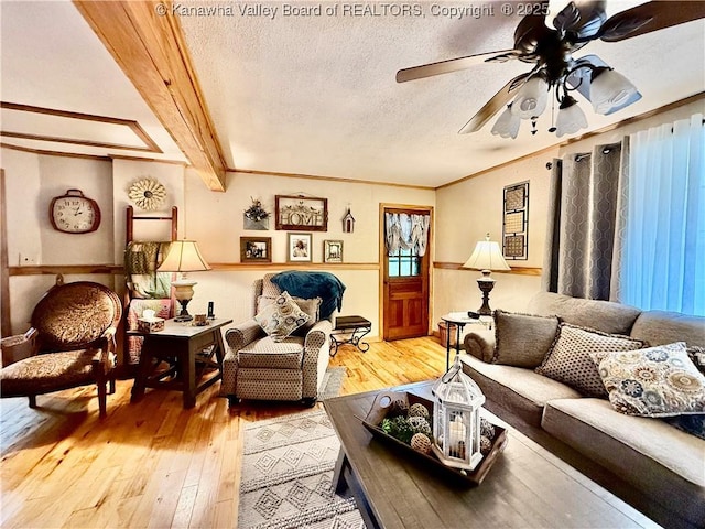 living room with beam ceiling, a textured ceiling, ceiling fan, and hardwood / wood-style floors