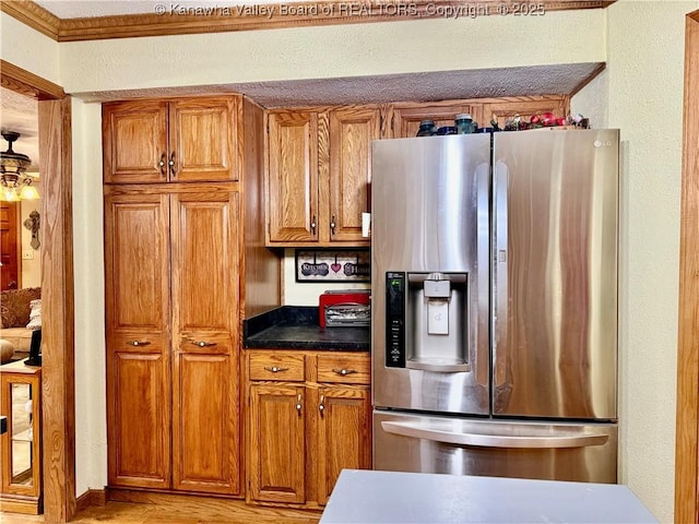 kitchen with stainless steel fridge and ornamental molding