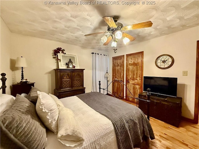 bedroom featuring a textured ceiling, light hardwood / wood-style floors, and ceiling fan