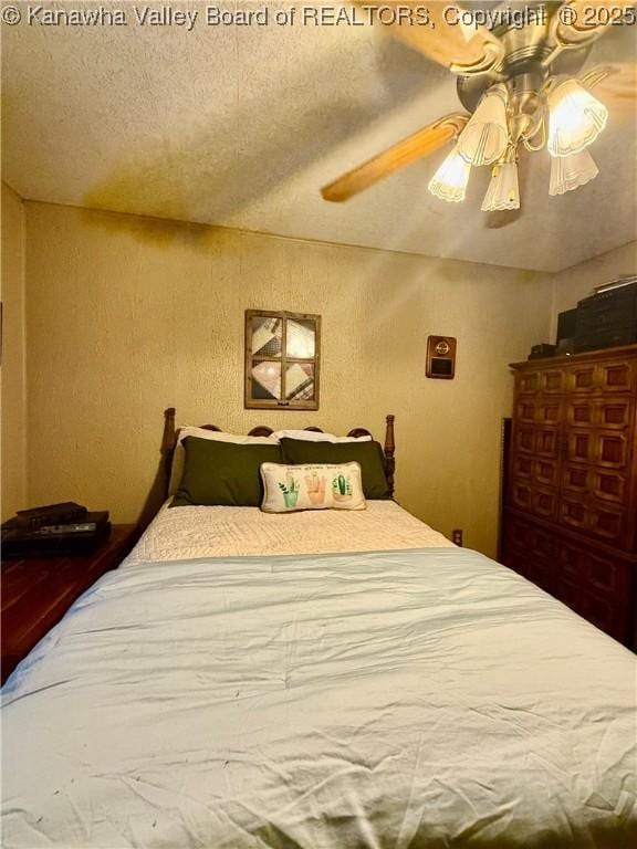 bedroom with ceiling fan and a textured ceiling