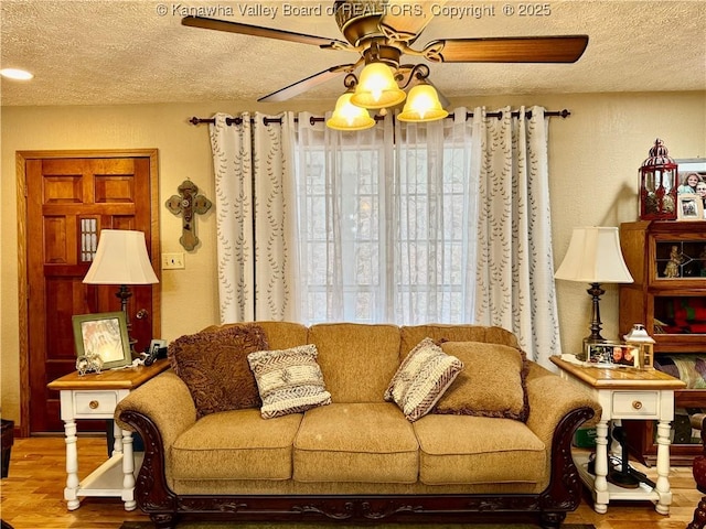 living room featuring hardwood / wood-style floors, plenty of natural light, ceiling fan, and a textured ceiling