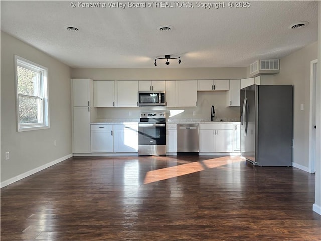 kitchen with white cabinetry, sink, dark hardwood / wood-style floors, and appliances with stainless steel finishes