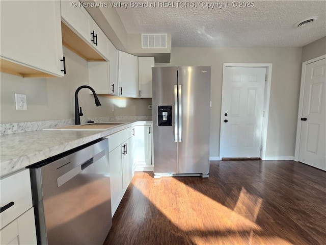 kitchen featuring dark hardwood / wood-style flooring, white cabinetry, sink, and appliances with stainless steel finishes