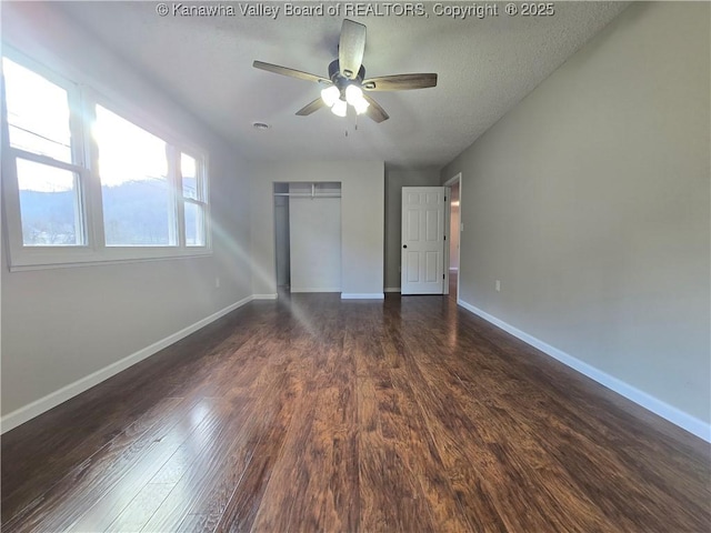 unfurnished bedroom featuring a closet, ceiling fan, dark hardwood / wood-style flooring, and a textured ceiling