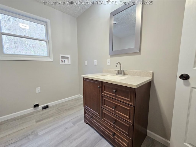 bathroom featuring hardwood / wood-style floors, vanity, and a textured ceiling