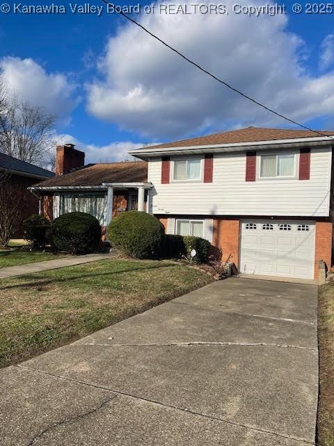 split level home with a garage and a front yard