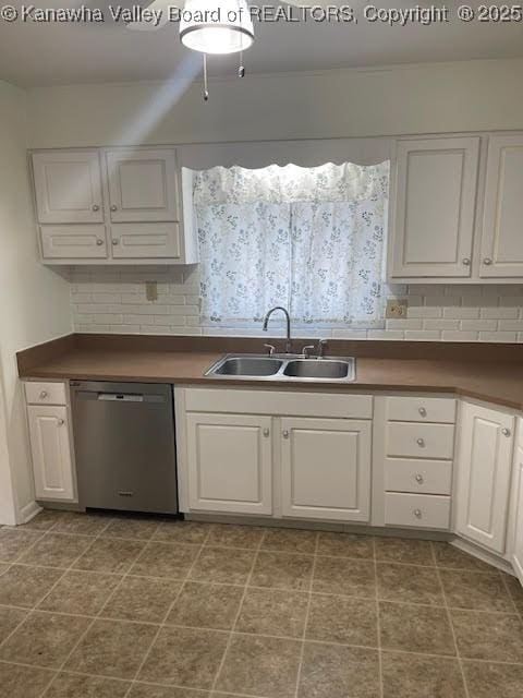 kitchen with stainless steel dishwasher, decorative backsplash, white cabinets, and sink