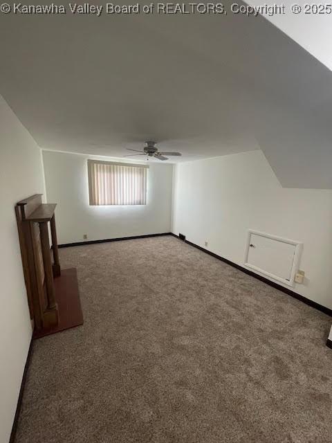 bonus room featuring ceiling fan, dark carpet, and lofted ceiling