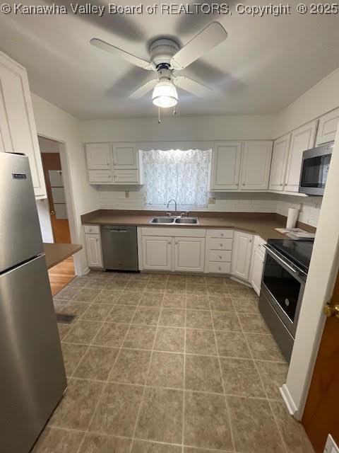 kitchen with white cabinets, ceiling fan, sink, and appliances with stainless steel finishes