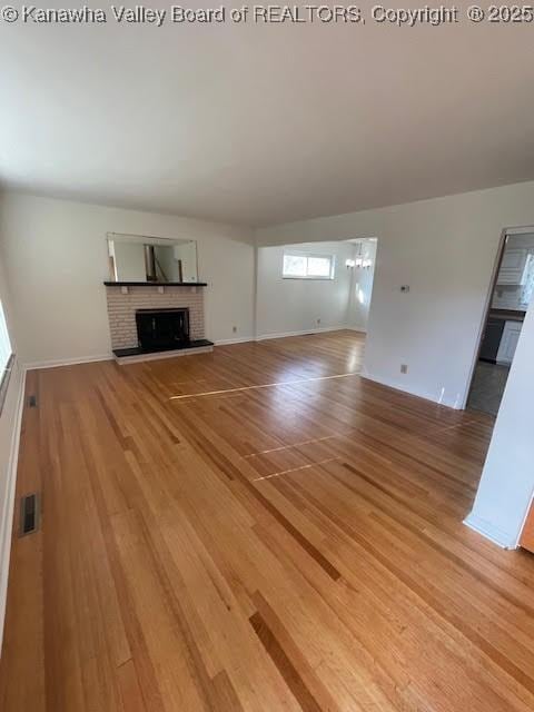 unfurnished living room featuring a fireplace and hardwood / wood-style flooring