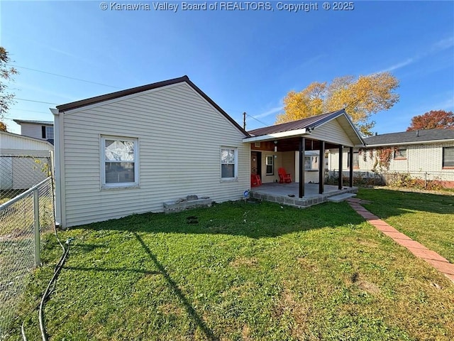 rear view of house featuring a lawn and a patio