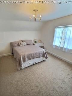 carpeted bedroom with lofted ceiling and a notable chandelier