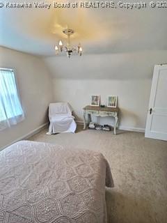 carpeted bedroom featuring a chandelier and vaulted ceiling