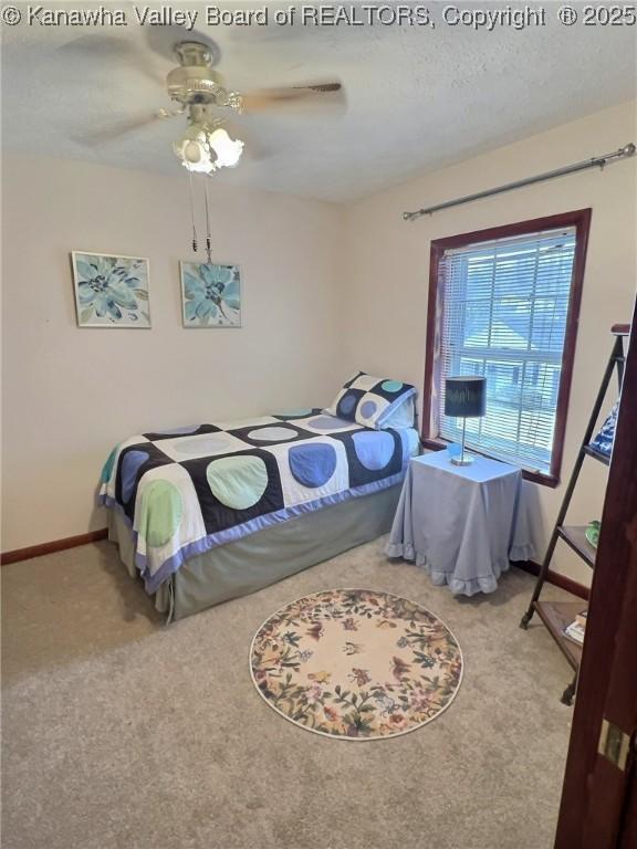 bedroom with carpet, ceiling fan, and a textured ceiling