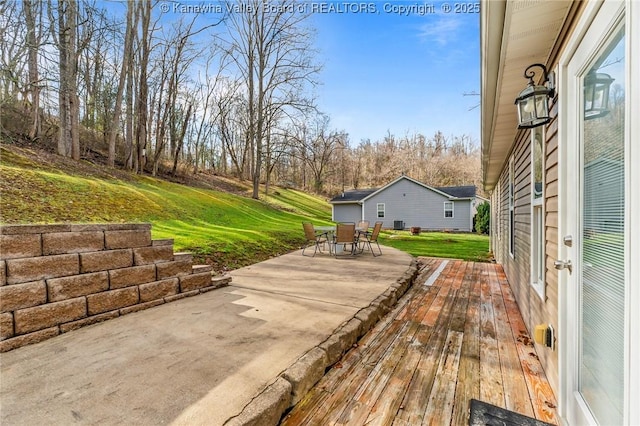 wooden terrace with a patio area and a yard