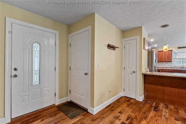 foyer with dark hardwood / wood-style floors, sink, and a textured ceiling