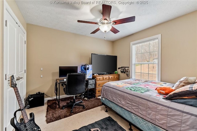 carpeted bedroom featuring ceiling fan, a textured ceiling, and a closet