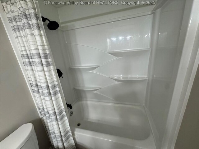 bathroom with toilet and shower / tub combo with curtain