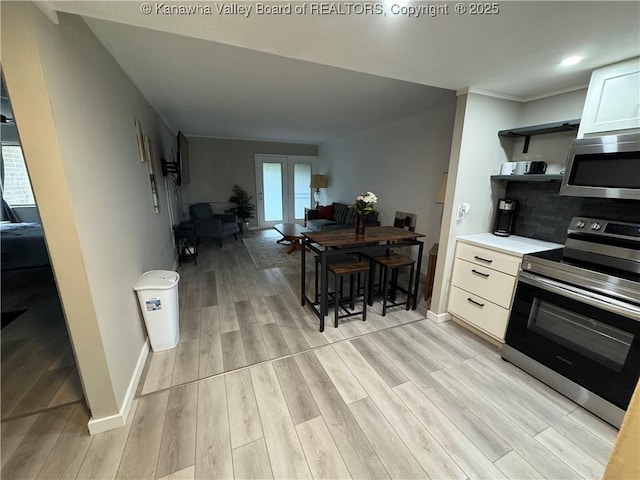 kitchen with white cabinetry, light hardwood / wood-style flooring, plenty of natural light, and appliances with stainless steel finishes