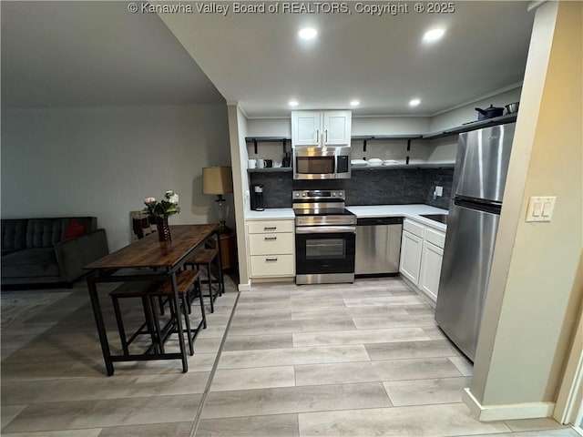 kitchen with appliances with stainless steel finishes, tasteful backsplash, and white cabinetry