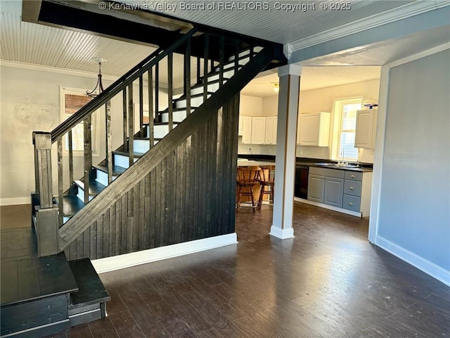 stairs featuring sink, hardwood / wood-style floors, and ornamental molding