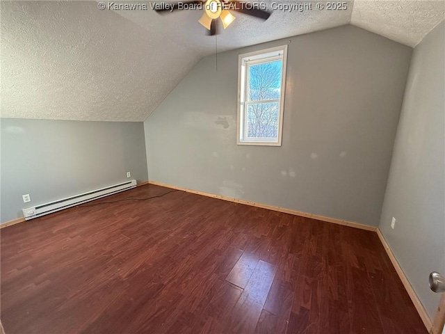 additional living space with ceiling fan, dark hardwood / wood-style flooring, a baseboard heating unit, lofted ceiling, and a textured ceiling