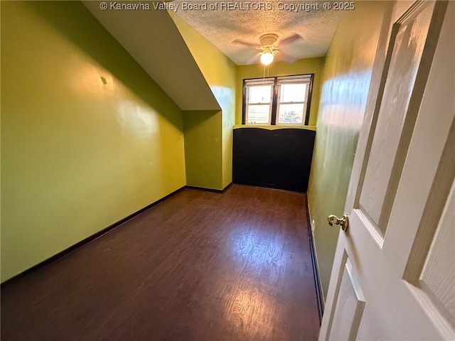 bonus room featuring ceiling fan, dark hardwood / wood-style flooring, and a textured ceiling