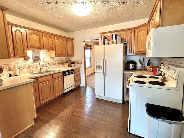 kitchen with sink, white appliances, dark hardwood / wood-style floors, and a textured ceiling