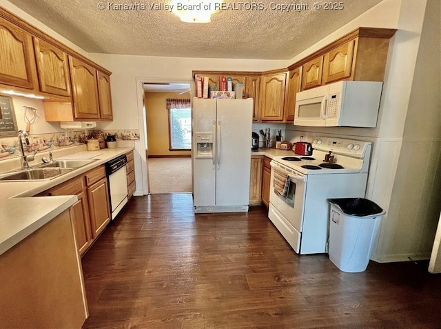 kitchen featuring white appliances, dark hardwood / wood-style flooring, sink, and a textured ceiling